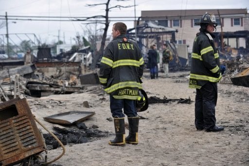 Bombeiros observam área devastada em Breezy Point, Queens, por incêndios e inundações. Foto: ©AFP / Stan Honda 