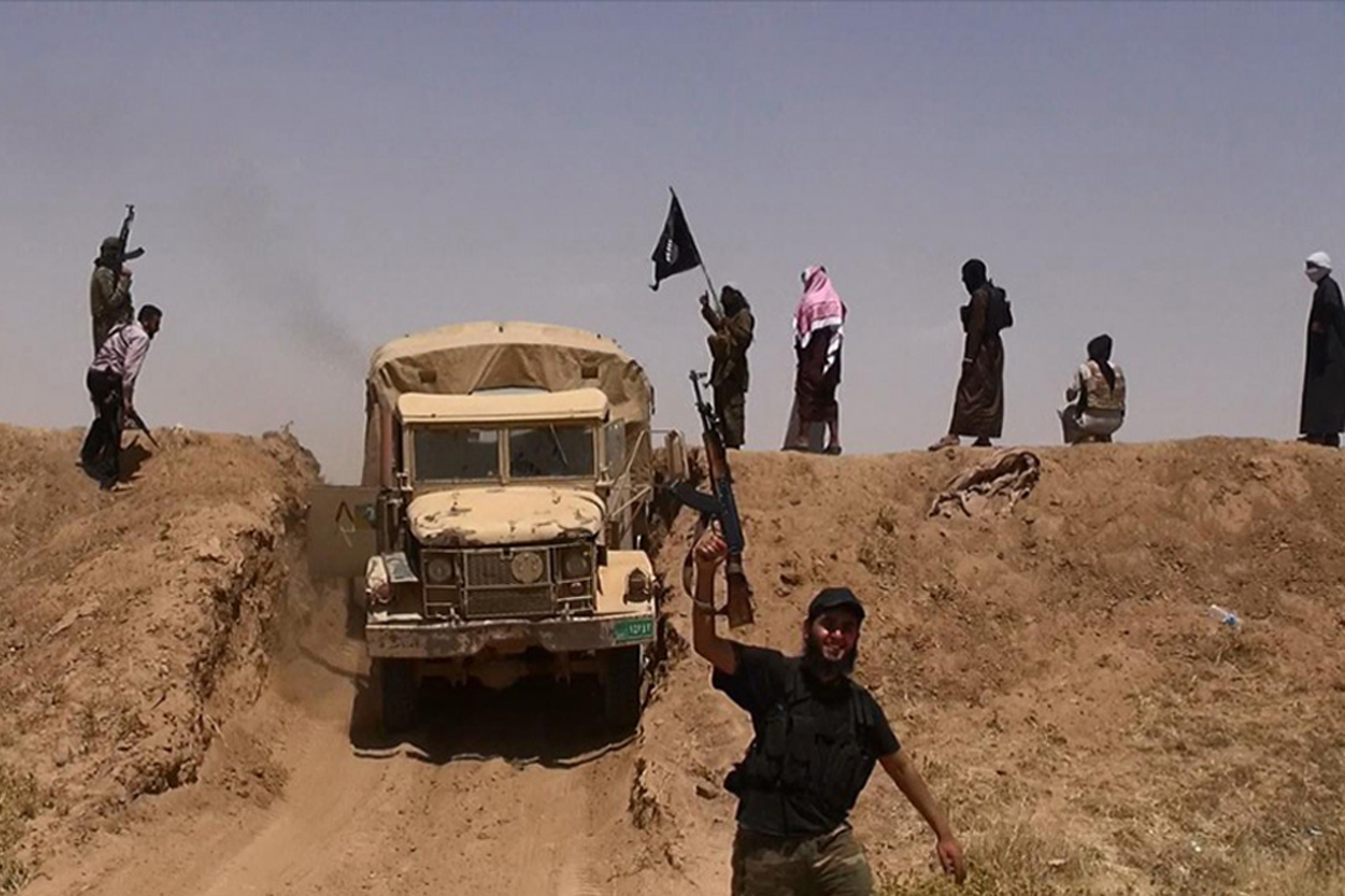 Militantes do Estado Islâmico (IS) acenam a bandeira  