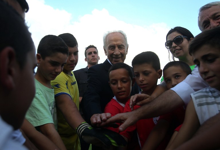 Shimon Peres, ex-presidente de Israel, com crianças israelenses e palestinas em torneio organizado por sua fundação no kibbutz de Dorot, sul de Israel. Há caminhos para a paz 