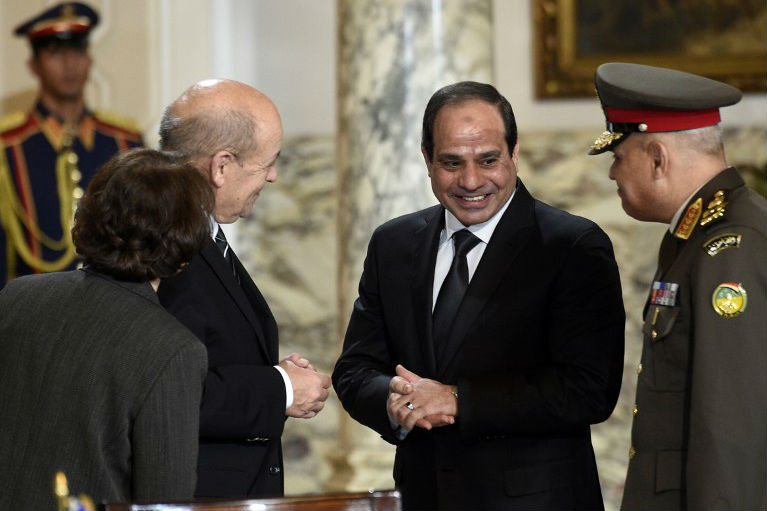 Sissi sorri ao receber o ministro da Defesa da França, Jean-Yves Le Drian (à esq.), para assinar, em 16 de fevereiro, o contrato da compra de 24 caças Rafale 