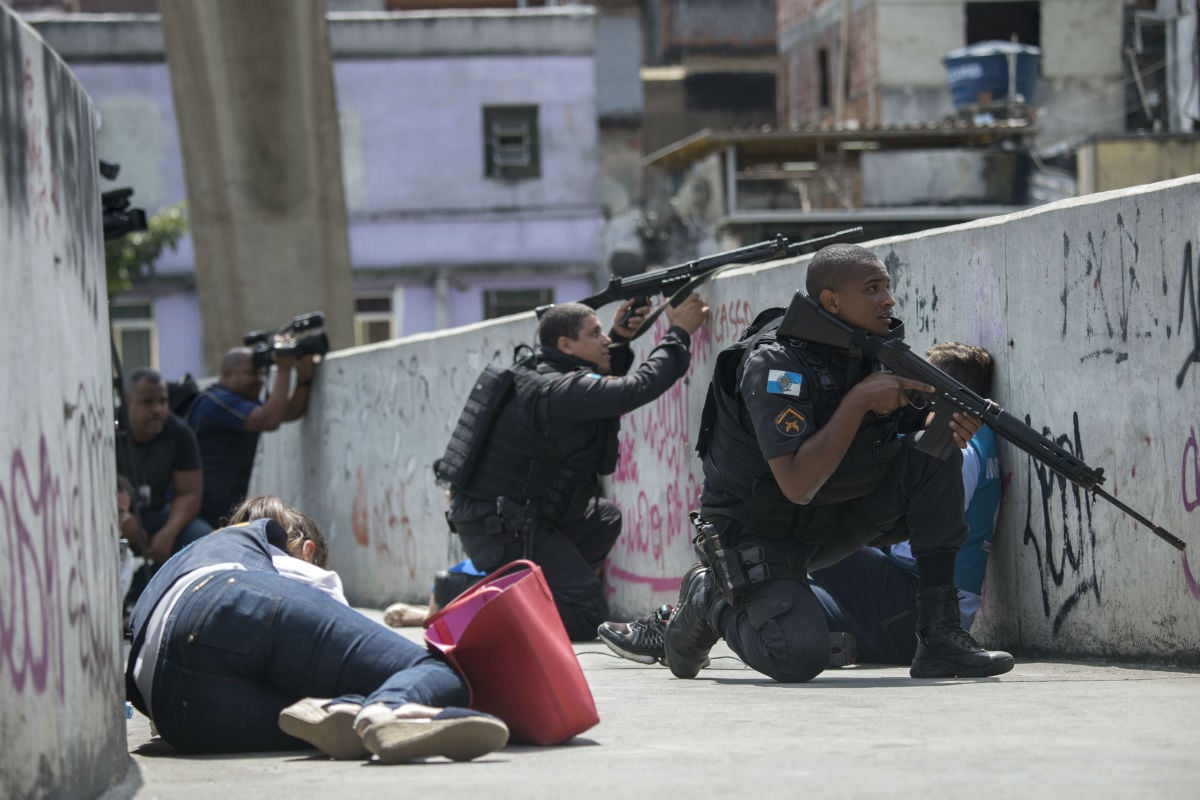 Moradores, profissionais da imprensa e policiais se protegem de tiros em passarela na Rocinha 