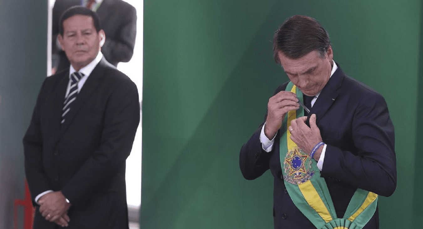 Jair Bolsonaro coloca faixa presidencial sob as vistas do vice-presidente Hamilton Mourão <i></noscript><img class=