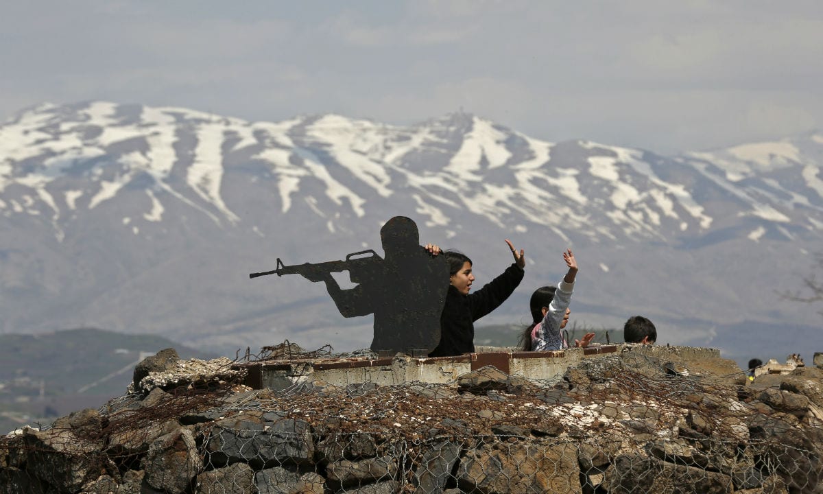 Turistas brincam em posto israelense nas colinas de Golã (Foto: AFP) 