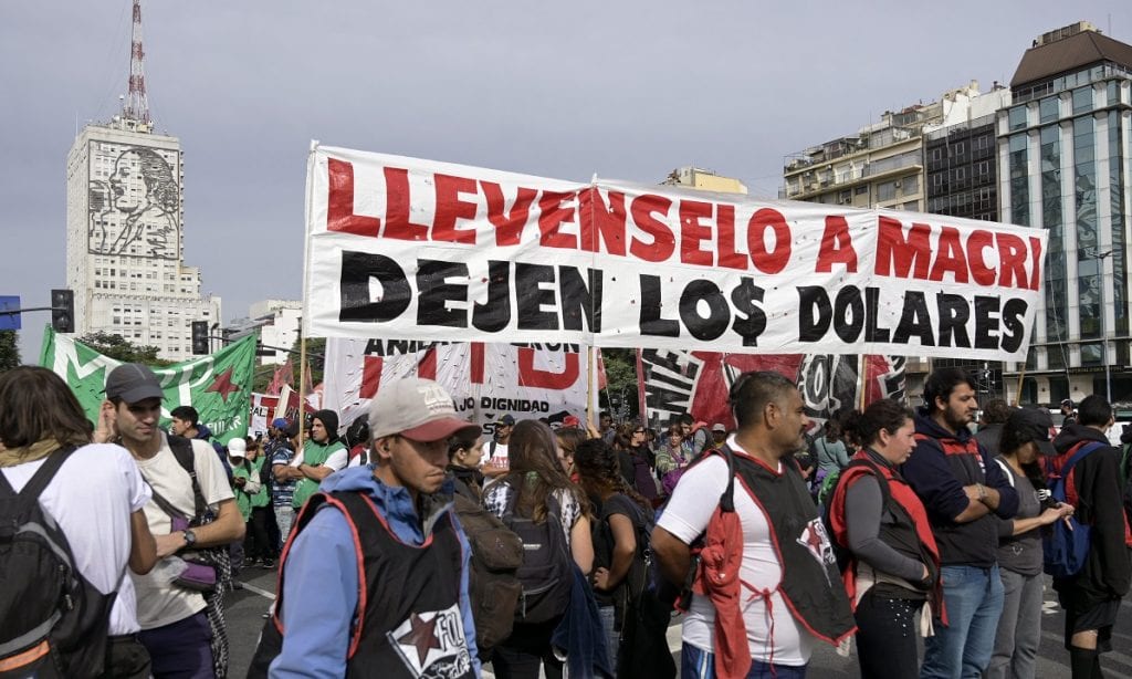 ARGENTINA: Manifestantes de organizações sociais marcham em Buenos Aires segurando uma faixa que diz: "Retirem Macri, nos livram os dólares" durante greve contra as políticas econômicas do presidente argentino (Foto: JUAN MABROMATA/AFP)