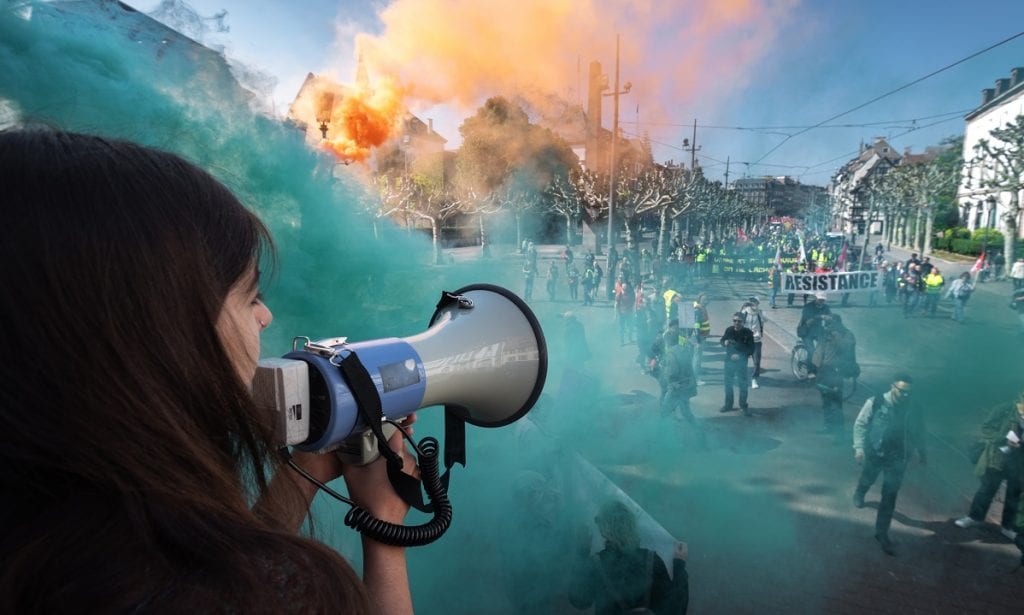 FRANÇA: Bombas de fumaça colorida se aproxima de pessoas que participam da reunião anual do Dia de Maio em Estrasburgo, no leste da França (Foto: PATRICK HERTZOG/AFP)