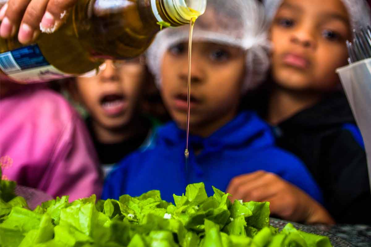 |Professora ensina os alunos a temperarem salada que irão consumir merenda alimentação escolar saudável|merenda alimentação escolar saudável