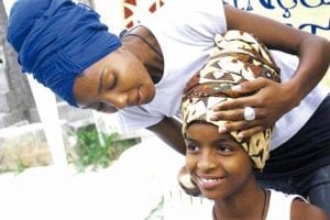 Oficina de turbante|Menina sorri com turbante na cabeça