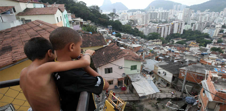 meninos se abraçam e observam favela