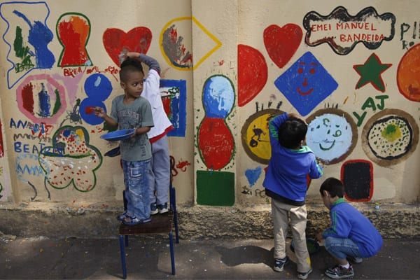 Crianças pintam muro de escola em São Paulo