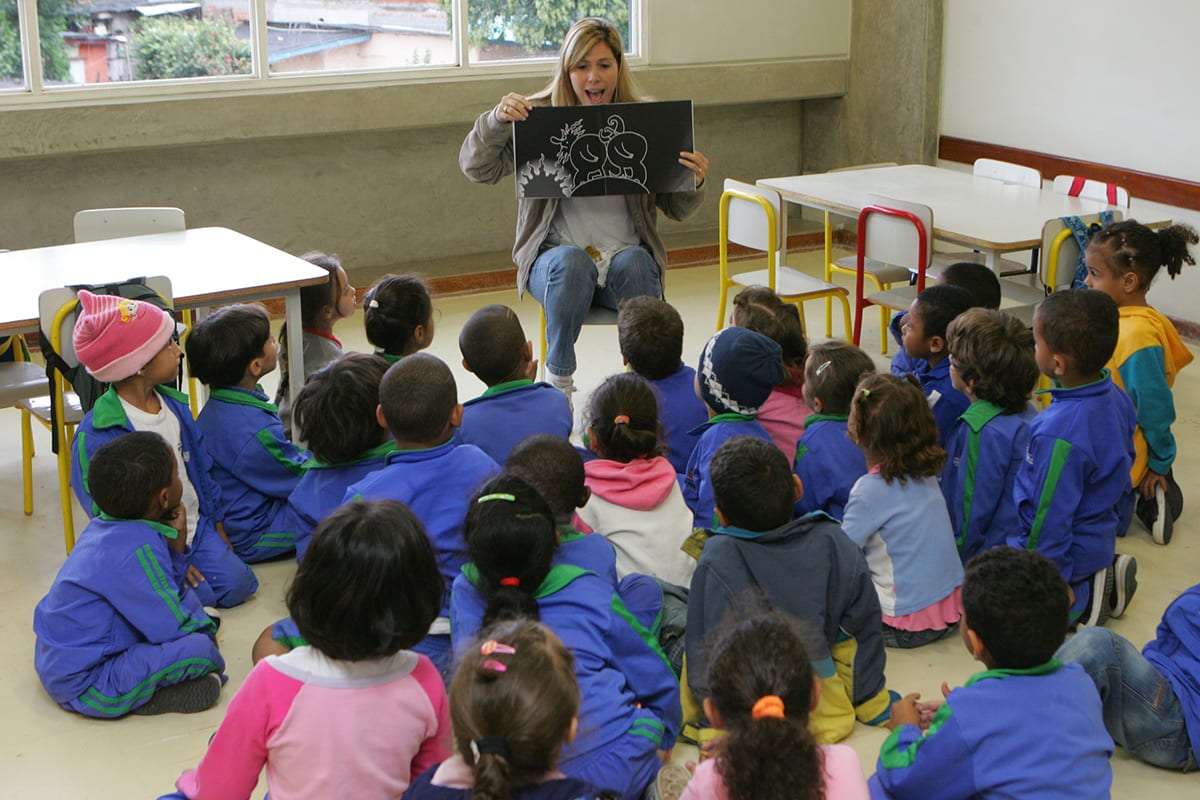 Professora lê com crianças na pré-escola