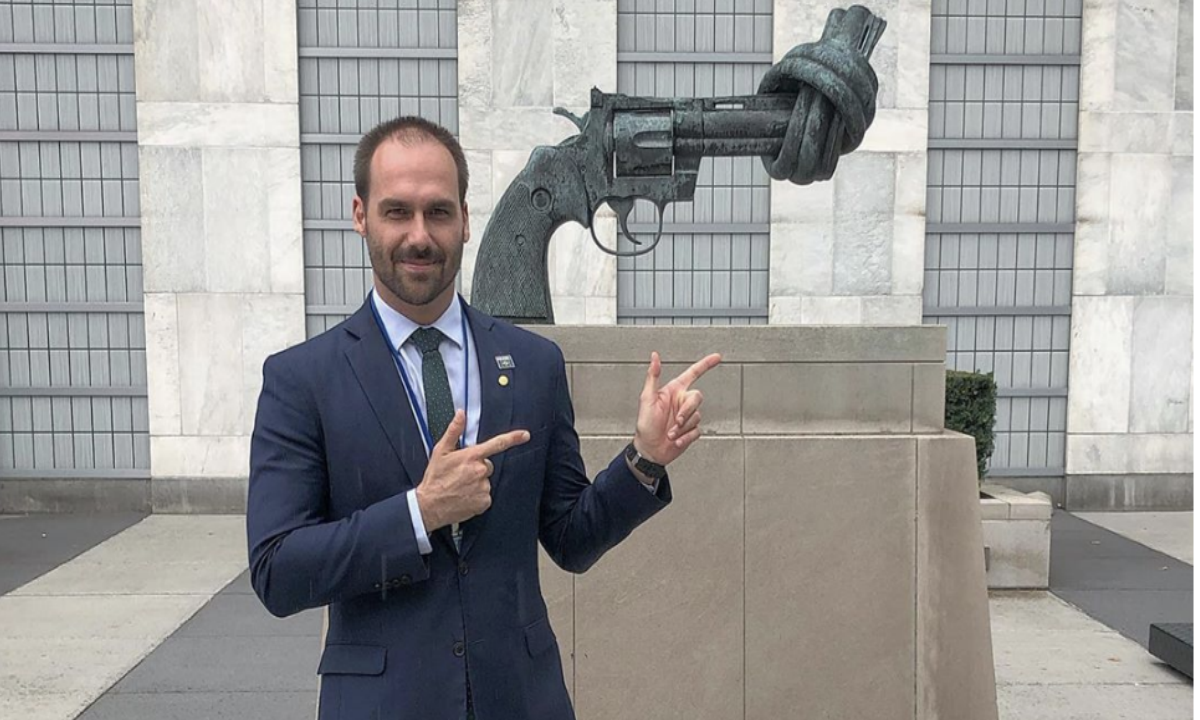 Eduardo posa em frente a escultura pela paz fazendo gesto de arminha (Foto: Rede social) 
