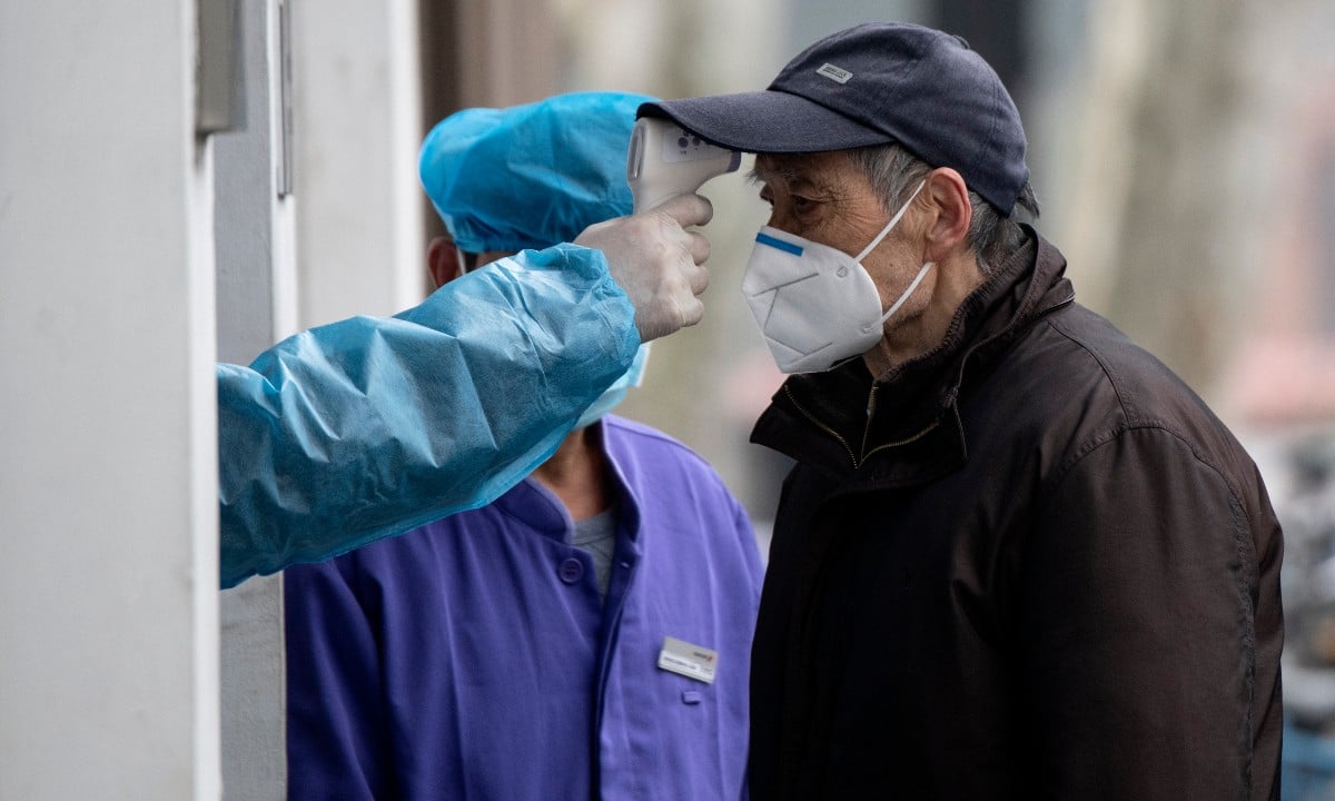 Cidadão faz teste de temperatura em medida de precaução por conta do novo coronavírus - Foto: NOEL CELIS/AFP 