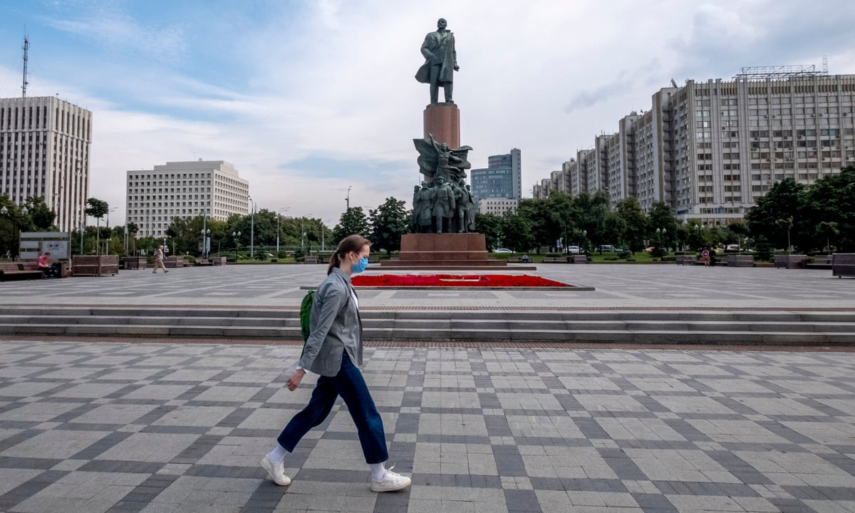 Mulher caminha de máscara na Rússia. Foto: Yuri KADOBNOV/AFP