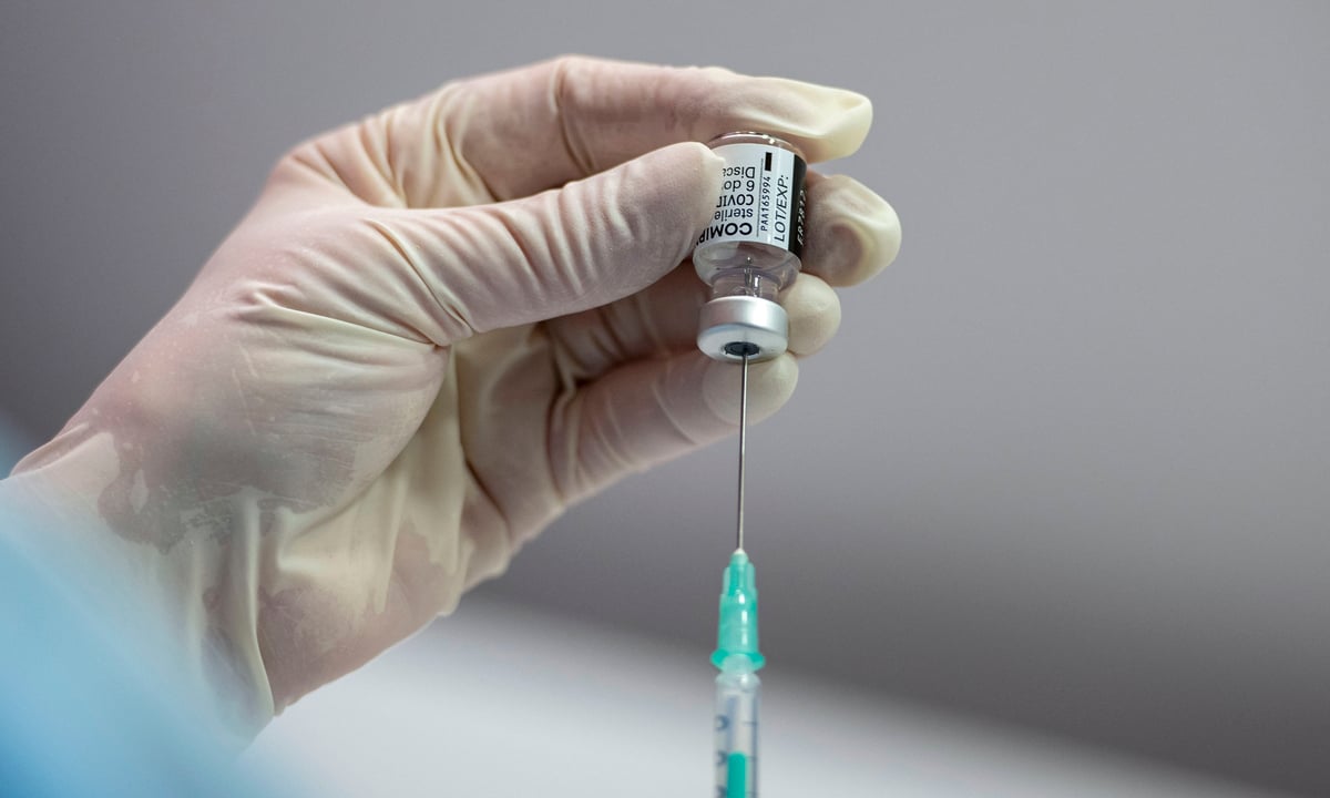 Profissional de saúde manuseia vacina da Pfizer. Foto: Thomas Lohnes/AFP 