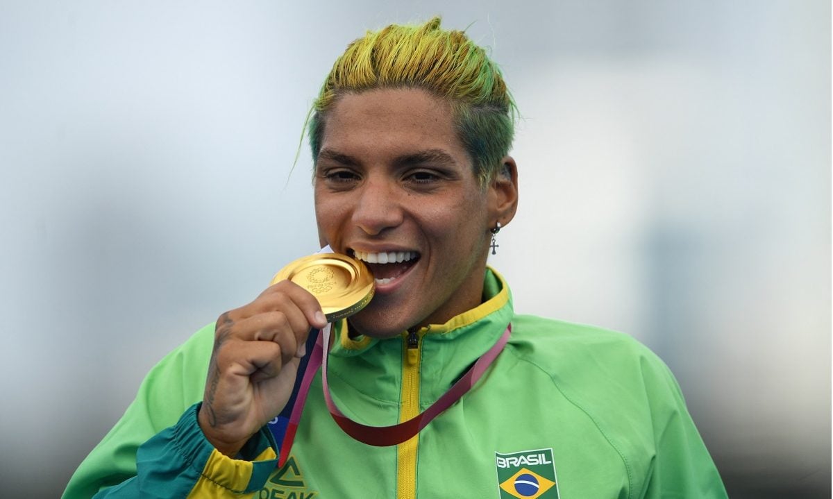 Ana Marcela Cunha morde sua medalha de ouro após vencer a maratona aquática feminina nos Jogos Olímpicos de Tóquio (Foto: Oli SCARFF / AFP) 