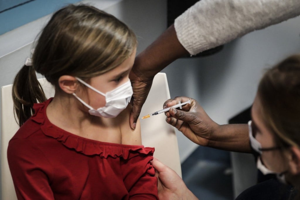 Menina toma dose da vacina em Paris. FOTO: GEOFFROY VAN DER HASSELT/AFP 