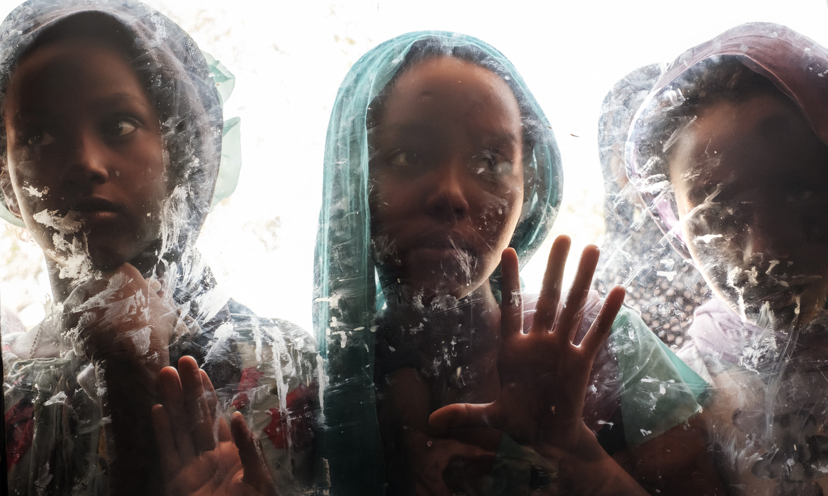 Meninas são vistas através de um vidro no complexo do Agda Hotel, na cidade de Semera, região de Afar, Etiópia. Foto: Eduardo Soteras/AFP 