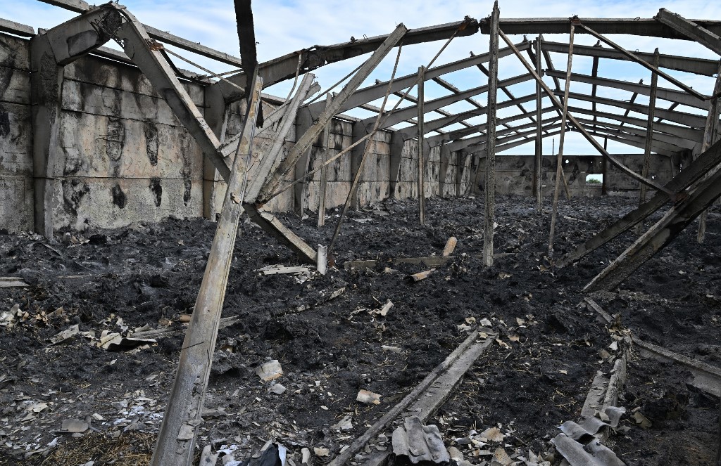 Fotografia mostra um armazém destruído após o bombardeio em uma fazenda do sul da Ucrânia, em Odessa, no dia 22 de maio de 2022. Foto de Genya SAVILOV/AFP 