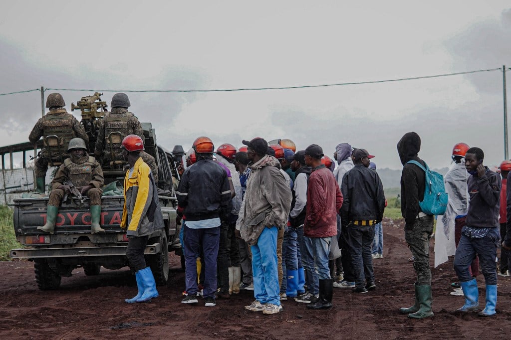 Moradores observam soldados da República Democrática do Congo. Foto: Aubin Mukoni/AFP 