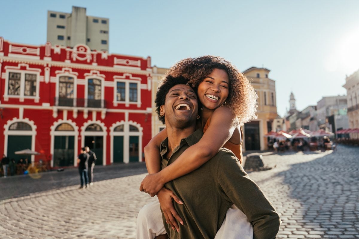 Woman on her boyfriend's back happy in the city 