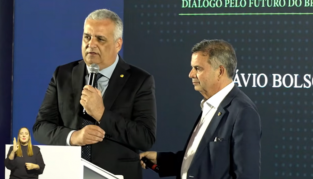 Vice de Flávio Bolsonaro se atrapalha em sabatina e é ‘salvo’ por coordenador da campanha; vídeo
